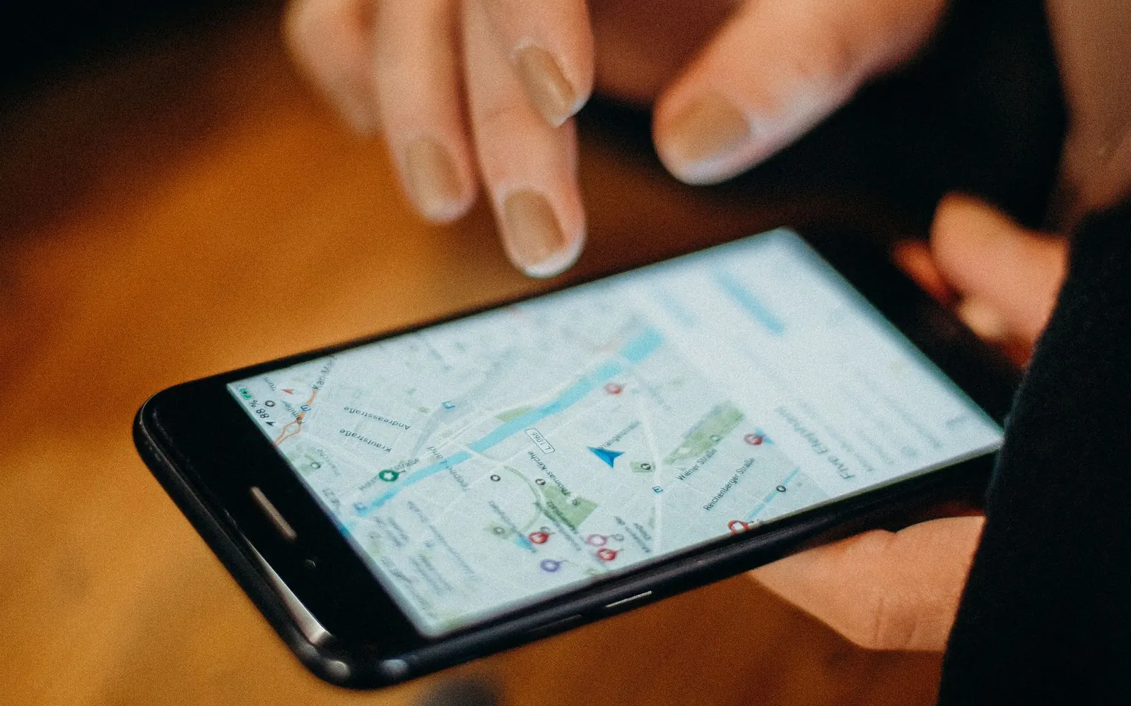 Mão segurando um celular com um mapa aberto na tela