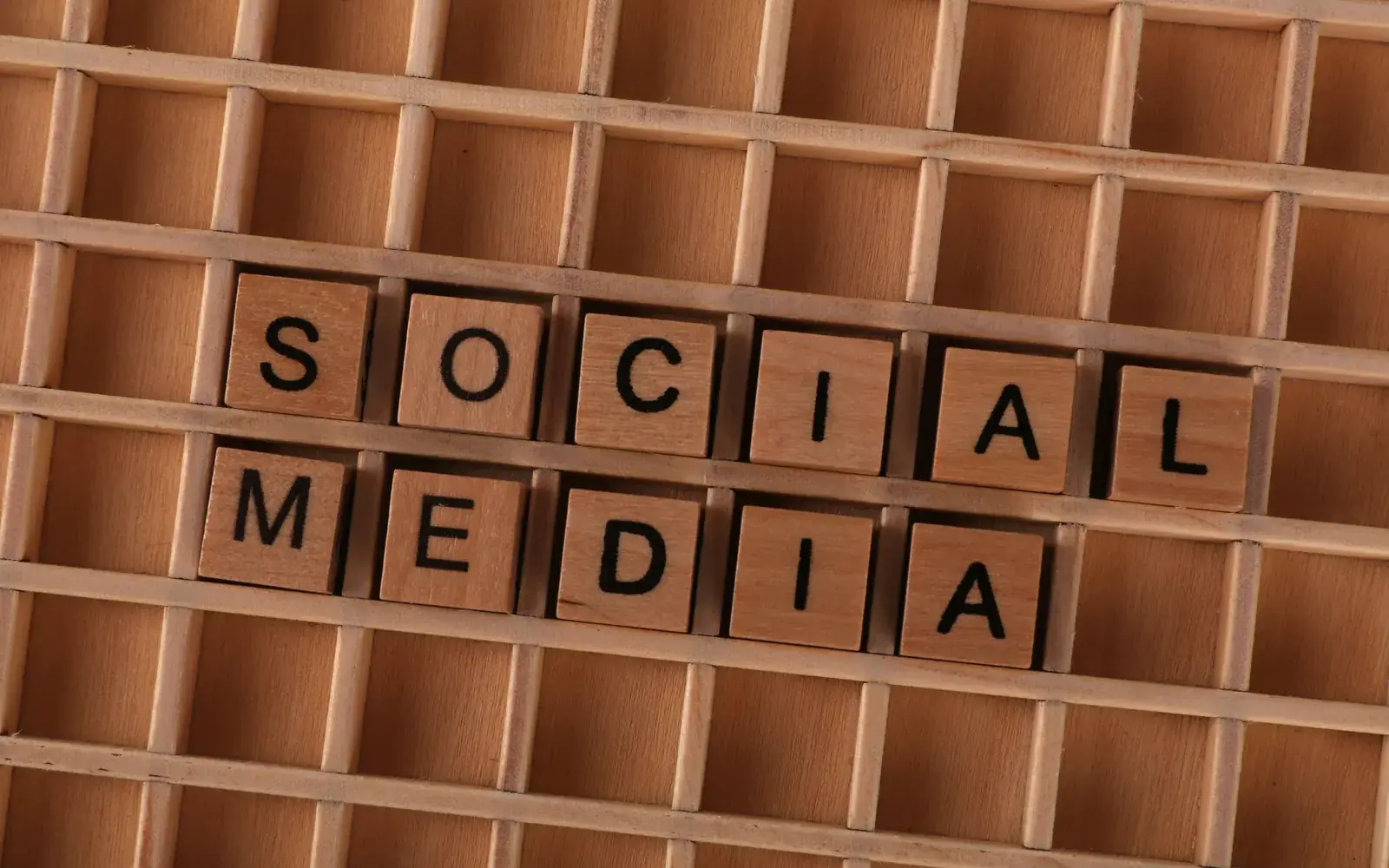Letras de madeira formando as palavras social media em uma caixa de tipos