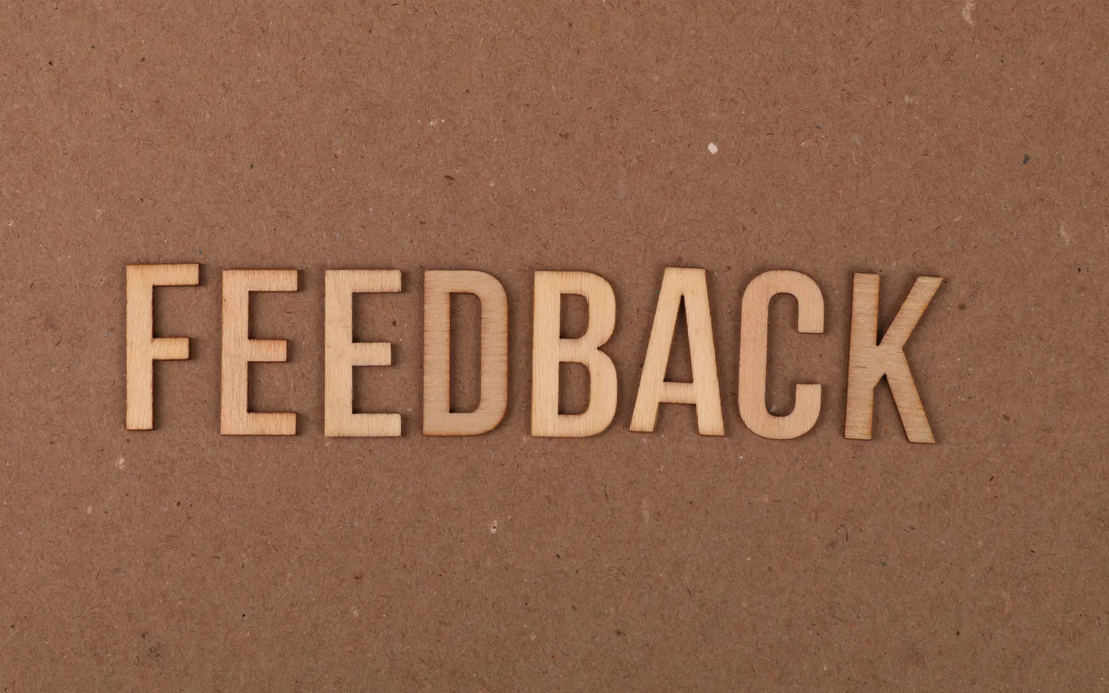 Palavra feedback em letras de madeira sobre papel kraft